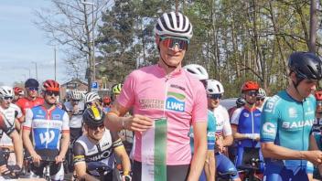 Lars Geisler freut sich über den Sieg und das rosa Trikot.