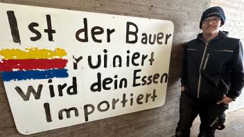 Landwirt Jann-Hendrik Arfsten von der Nordseeinsel Föhr hat das Protestplakat zur Erinnerung an die Bauerndemo in Berlin auf seinem Hof angebracht. 