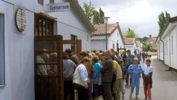 Aussiedler drängen sich vor dem Speiseraum im Grenzdurchgangslager Friedland. 