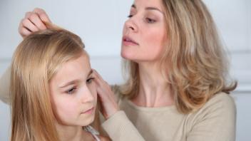 Mother treating daughter&apos;s hair against lice