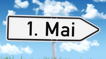 6 April 2024: Signpost against a blue sky with the inscription: May 1. PHOTOMONTAGE *** Wegweiser vor blauem Himmel mit 