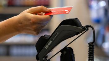 03.01.2024, Frau bezahlt mit der EC-Karte im Geschäft. Kontaktloses Bezahlen mit dem NFC-Chip. 03.01.2024, Kartenzahlung