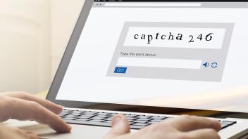 home computing captcha, man using a laptop with captcha on the screen. Screen graphics are made up.