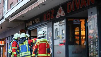 Einsatzkräfte der Feuerwehren aus Elmshorn und Kölln-Reisiek begutachten den Brandort, ein bekannter Döner-Imbiss an der Königstraße.