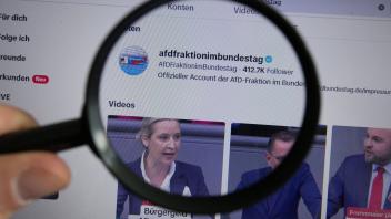 Eine Lupe vergrößert der Account der Bundestagsfraktion der Alternative für Deutschland auf dem Videoportal TikTok. Symb