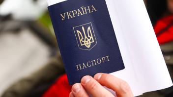 Mobile Passport Point For Ukrainians In Poland An Ukrainian citizen is holding a passport while standing by a mobile pas