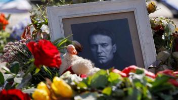 TOPSHOT - Flowers are left next to a photo of the late Russian opposition leader Alexei Navalny at a makeshift memorial in front of the Russian Embassy in Berlin on March 19, 2024. Yulia Navalnaya, the widow of Kremlin foe Alexei Navalny, called on Russians who oppose President Vladimir Putin "not to give up", on March 19, 2024 while dismissing Moscow&apos;s election result as having "no meaning". (Photo by David GANNON / AFP)