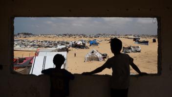 TOPSHOT - Palestinian children stand in a camp for displaced people in Rafah in the southern Gaza Strip by the border with Egypt on April 28, 2024, amid the ongoing conflict between Israel and the Palestinian militant group Hamas. (Photo by AFP)