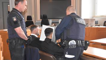 Justizwachtmeister nehmen Danial A. (27) auf der Anklagebank die Handschellen ab.