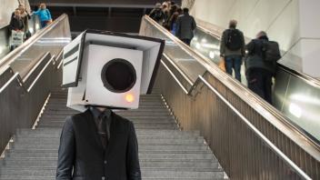 Ein Teilnehmer mit einer Maske in Form einer Überwachungskamera bei einer Aktion gegen gegen den Aus