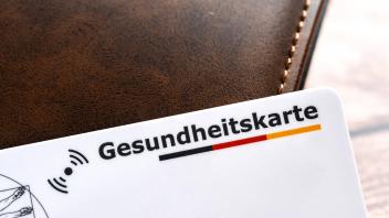 Augsburg, Bavaria, Germany - February 18, 2024: Health insurance card next to a wallet *** Gesundheitskarte einer Kranke