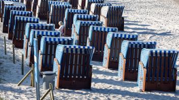 Maiwetter auf Ruegen Eine Urlauberin sitzt inmitten leerer Strandkoerbe in Binz der Insel Ruegen. Deutschlands groesste 