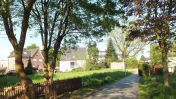 Auf dieser Grünfläche entsteht demnächst ein Einfamilienhaus. Im Hintergrund die Trafostation und die alte Eiche an der Straße Im Siek". 