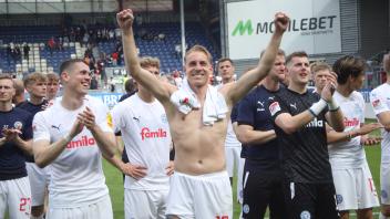 Holstein Kiels Siegtorschütze Timo Becker (Mitte) lässt sich nach dem Spiel feiern.