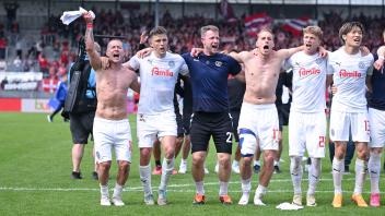 Die Spieler von Holstein Kiel feiern den 1:0-Sieg in Wiesbaden. 