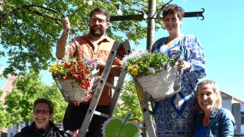 Sie befestigen die ersten beiden Kübel mit insektenfreundlichen Blumen: Marc Hein (oben links) und Dana Westphal vom Citymanagement, gemeinsam mit Verena Kaspari (unten links) und Marion Möller von dem Verein Naturhelden.