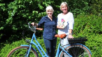 Anja Lübben (li.) und Susanne Schmahl bieten bei der Stadtinfo neben den neuen Miet-E-Bikes auch das passende Kartenmaterial für Touren an