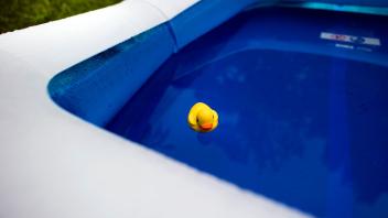 Eine gelbe Plastik-Ente schwimmt in einem Pool
