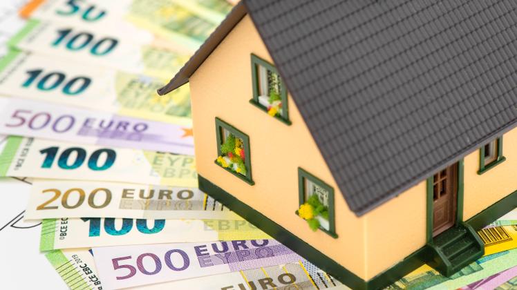Baufinanzierung für Hausbau und Hauskauf Ein Modellhaus steht auf vielen Euro Banknoten als Symbol für Finanzierung von 