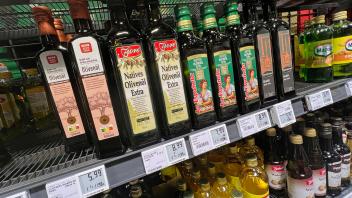 Flaschen mit Olivenöl im Supermarkt-Regal: Nach der Preisexplosion sollen die Produkte nun wieder günstiger werden.