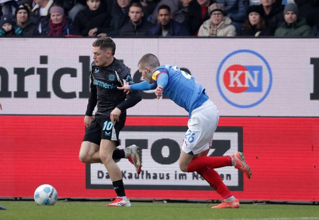David Zec dans un duel avec Florian Wirtz: Le Slovène au service de Holstein Kiel a dû être remplacé contre Bayer Leverkusen en raison d'une carte rouge jaune imminente. David Zec dans un duel avec Florian Wirtz: Le Slovène au service de Holstein Kiel a dû être remplacé contre Bayer Leverkusen en raison d'une carte rouge jaune imminente.