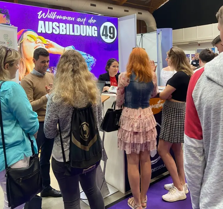 Students interacting with company representatives at‍ the JF Messe Ausbildung job fair.
