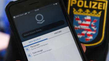 Ein Polizist in Hessen zeigt ein Dienstsmartphone mit Palantir-Software
