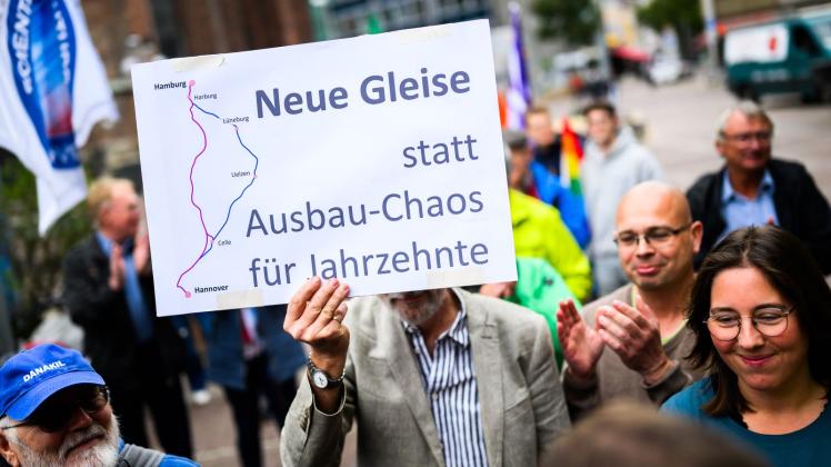 <p>Demonstranten stehen mit Schildern am Rande eines Treffens der Deutschen Bahn vor dem Alten Rathaus. Fridays for Future, der VCD Landesverband Niedersachsen und weitere Organisationen setzen sich für eine Verkehrswende und eine Bahn-Neubaustrecke Hamburg-Hannover ein. (zu dpa: «Bahnstrecke Hamburg-Hannover: Bahn ist für Neubau»)</p>