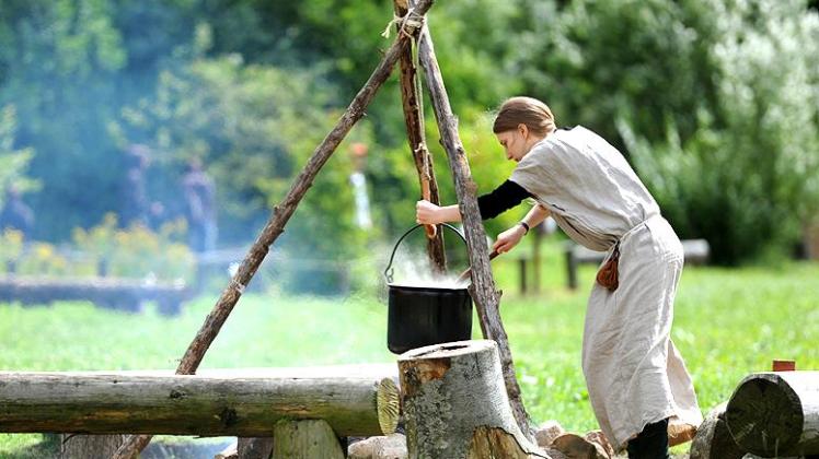 Leben wie unsere Vorfahren vor Tausenden Jahren kann man im Steinzeitdorf. Eine Studentin kocht auf einem offenen Feuer im Steinzeitpark bei Albersdorf, Deutschland, am 20.07.2012. Leben wie unserer Vorfahren vor Tausenden Jahren kann man im Steinzeitdorf. Photo: Daniel Reinhardt ACHTUNG Das Bild hat dpa auch im Bildfunk gesendet +++(c) dpa - Nachrichten für Kinder+++Leben wie unsere Vorfahren vor Tausenden Jahren kann man im Steinzeitdorf. Eine Studentin kocht auf einem offenen Feuer im Steinzeitpark bei Albersdorf, Deutschland, am 20.07.2012. Leben wie unserer Vorfahren vor Tausenden Jahren kann man im Steinzeitdorf. Photo: Daniel Reinhardt ACHTUNG Das Bild hat dpa auch im Bildfunk gesendet +++(c) dpa - Nachrichten für Kinder+++