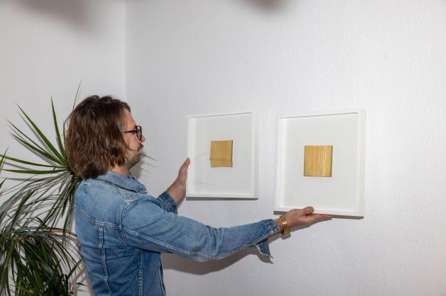 ...oder lieber so? Benedikt Schlereth probiert aus, wie sich die Leihkunst aus der Artothek an der Wand seines Schlafzimmers macht.