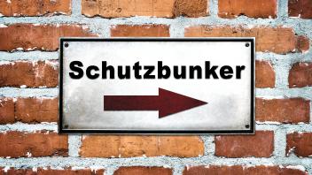 Deutschladn - November 26, 2024: A signpost to the shelter on a brick wall. Symbolic image for security and protection i