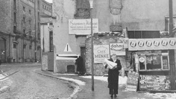 Blick vom westlichen Ausgang des Neumarkts in den Neuen Graben vor der Verbreiterung. Abenteuerliche Kurven musste der Verkehr beschreiben, weil ruinöse Altbauten wie hier die Papierhandlung Bergmann & Heitmeyer im Wege standen. Links trotzen noch die Betriebsgebäude der Schnapsbrennerei Gosling dem Abriss. Später entstand hier das Kaufhaus Hertie. 