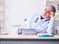 Old male doctor working in the clinic