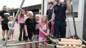 Emiliy, Melvin und Finnley (vorn, von rechts) spielen Jenga mit dem hydraulischen Spreizer von Maurice Thamsens aus der Bergungsgruppe.
