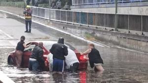 Mit vereinten Kräften versuchten die Menschen am Montagabend, ein Auto aus der Unterführung in der Wasserstraße in Elmshorn zu schieben.