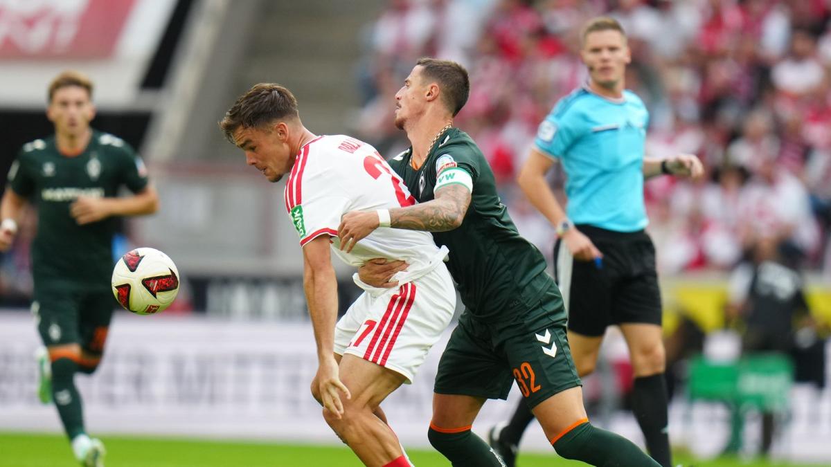 Kölns Thijs Dallinga (l) und Bremens Marco Friedl kämpfen ums den Ball
